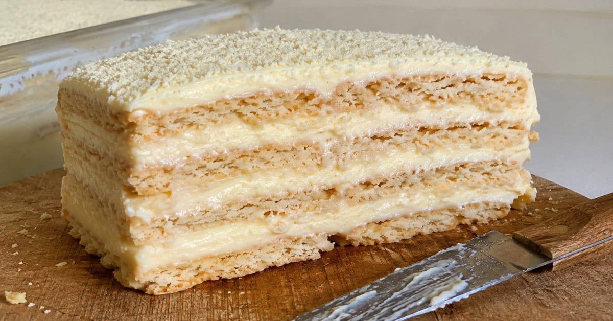 Torta Alemã de Leite Ninho 4 Fatia perfeita de torta alemã de leite ninho cortada em tábua de madeira mostrando as camadas