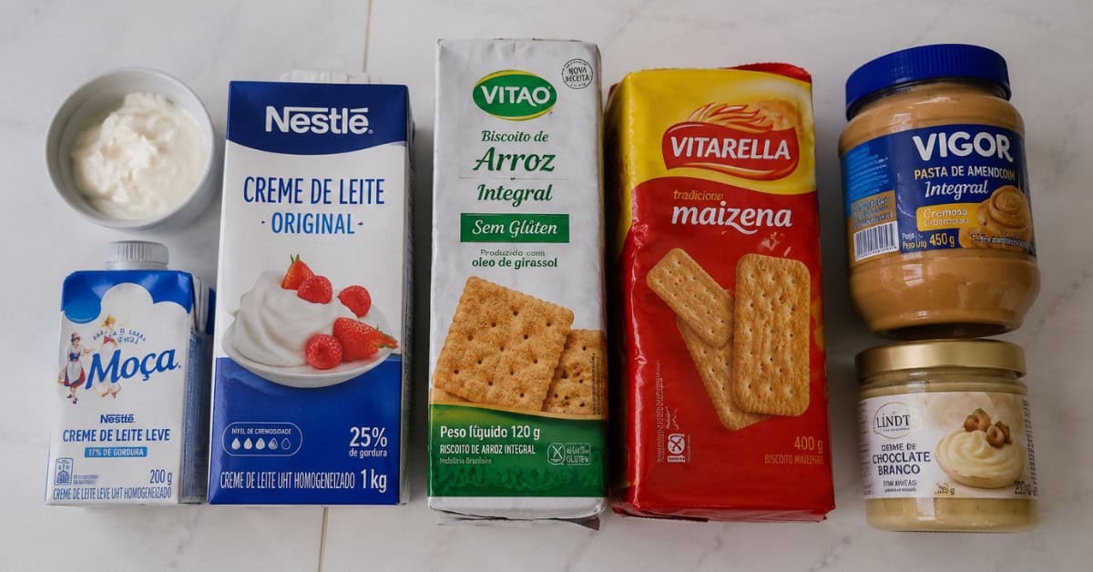 Torta Alemã de Leite Ninho 3 Ingredientes alternativos para torta alemã de leite ninho: biscoito sem glúten, creme de coco e pasta de amendoim sobre superfície branca