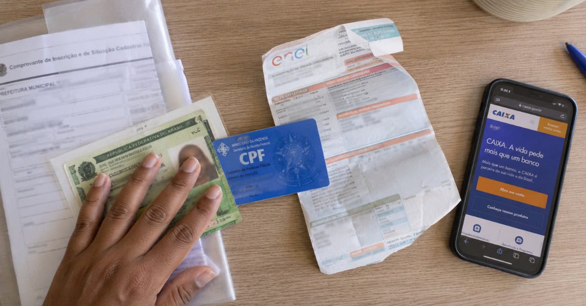 Como Conseguir uma Casa na Minha Casa Minha Vida 3 Documentos espalhados na mesa para inscrição no Minha Casa Minha Vida, incluindo RG, CPF e comprovante de residência
